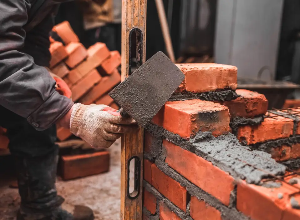 brickmason working on brick building chimney