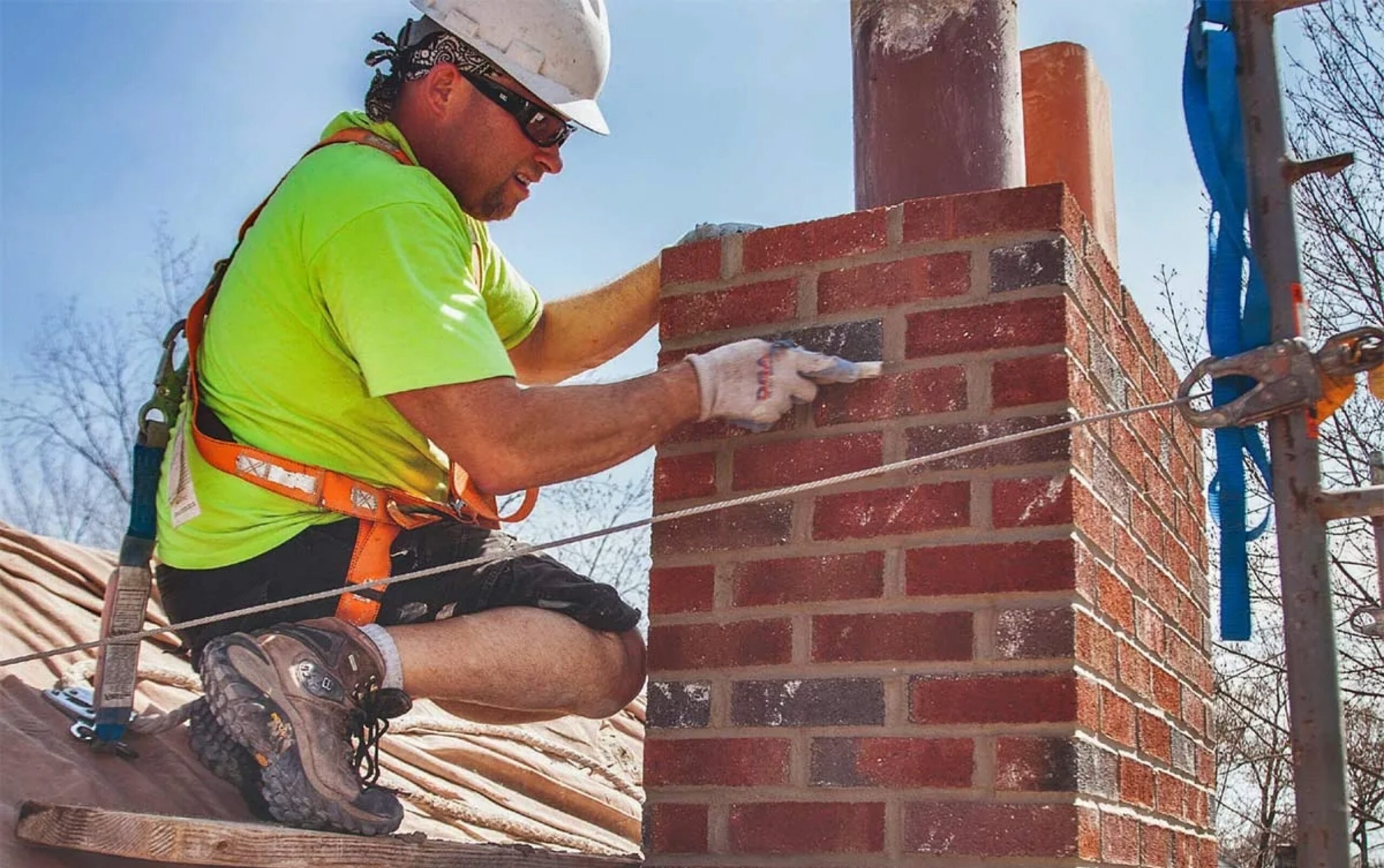 Tech on roof with safety gear.