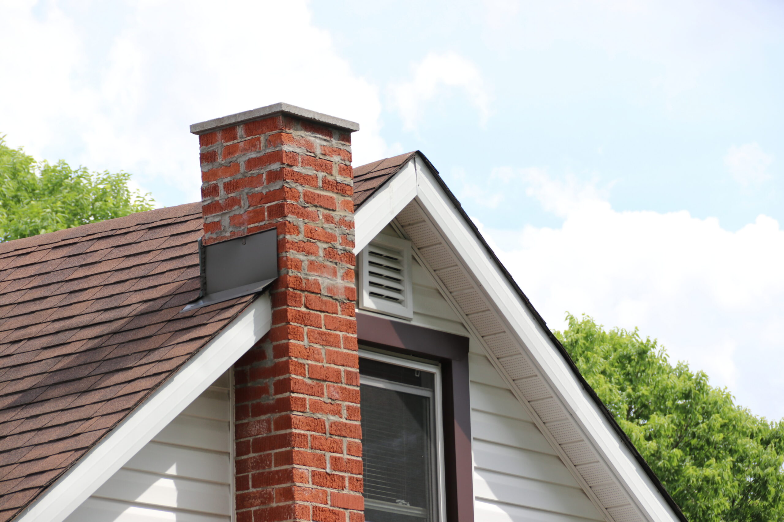 A tall brick chimney against a clear blue sky.
