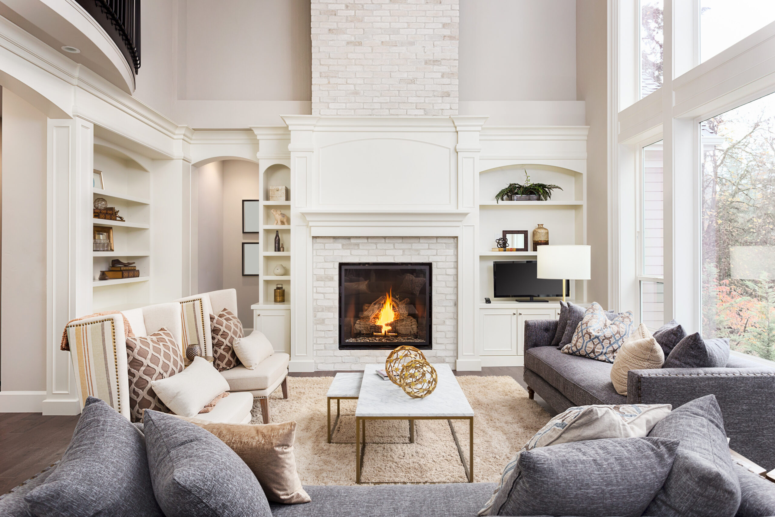 Adobe Stock image of a fireplace with a white brick surround in a nicely decorated living room.